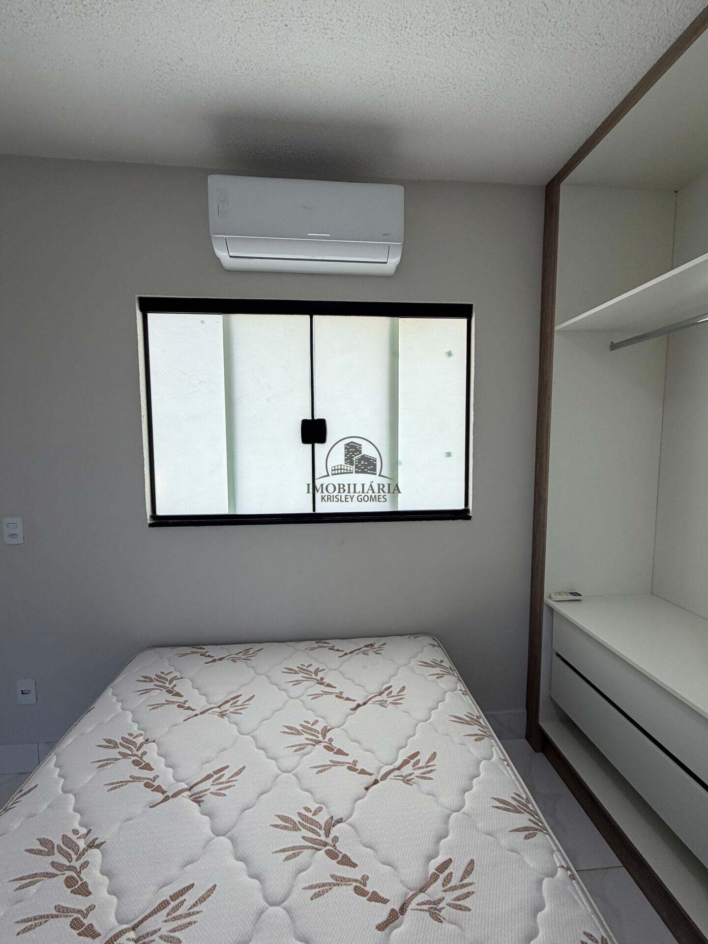 Quarto com guarda-roupa e janela ampla